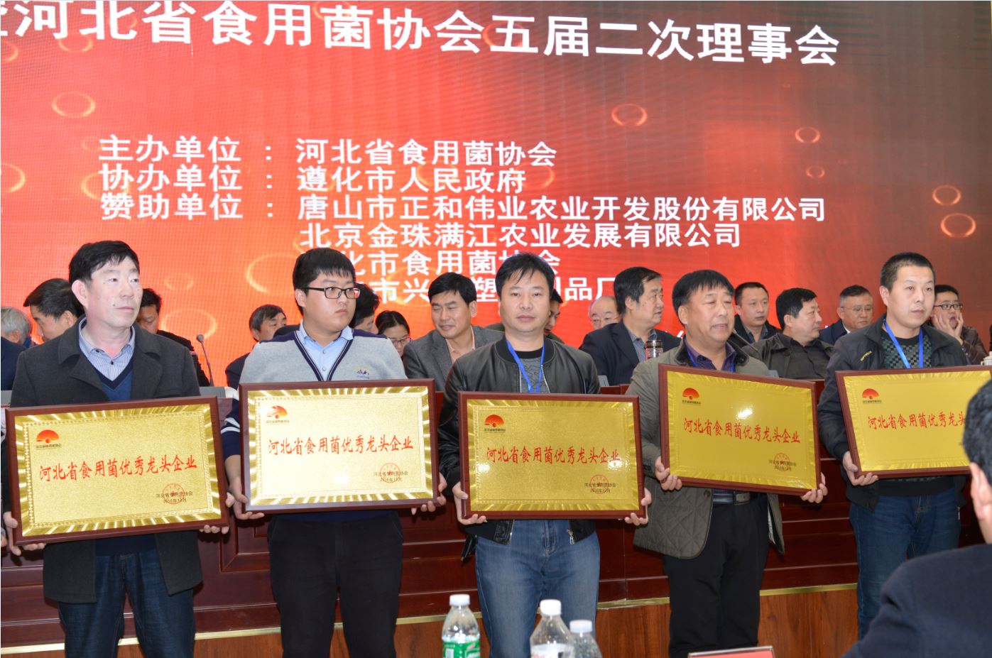 遵化市億昌食用菌科技有限公司被授予&ldquo;河北省食用菌產(chǎn)業(yè)扶貧突出貢獻(xiàn)單位&rdquo;榮譽(yù)，張東平（中）接授牌匾（截屏）.JPG